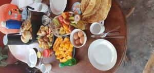 a table filled with various types of breakfast foods at Jambiani Holiday House in Jambiani