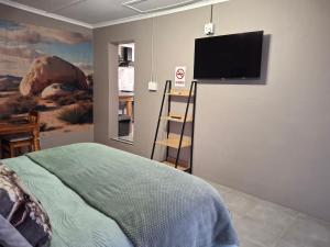 a bedroom with a flat screen tv on the wall at 3de laan Springbok in Springbok