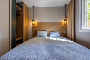 a bedroom with a large bed with two pillows at Camping le Clou in Coux-et-Bigaroque