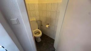 a small bathroom with a toilet in a stall at Hotel und Gaststätte zum Grafenwall in Recklinghausen