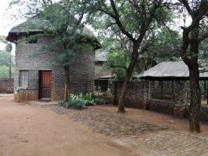 a brick building with a tree in front of it at Roundhouse Marloth Park in Marloth Park