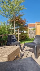 two chairs and a table on a wooden deck at LAMELINE in Échenoz-la-Méline