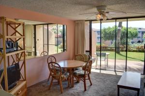 a living room with a table and chairs and a tv at Maui Vista 3105 in Kihei