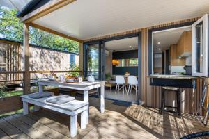 a screened in porch with a table and a stove at Camping le Clou in Coux-et-Bigaroque