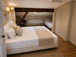 a bedroom with a bed with white sheets and pillows at La Maison Bordeaux in Bordeaux