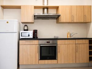 a kitchen with a white refrigerator and a microwave at Comfort & Central Rooms in Luxembourg