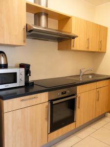 a kitchen with a microwave oven and a sink at Comfort & Central Rooms in Luxembourg +13 photos