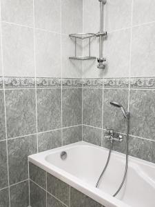 a bathroom with a bath tub with a shower at Comfort & Central Rooms in Luxembourg