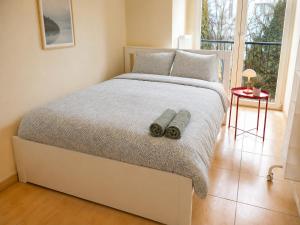 a bedroom with a white bed with two towels on it at Comfort & Central Rooms in Luxembourg