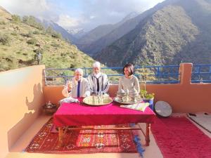 a group of people sitting at a table on a balcony at Imlil agarssiwal in Aguersioual