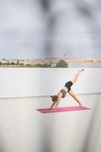 a woman doing a handstand on a yoga mat at Dar D'art Luz Galerie Boutique Guest house in Al Ghar