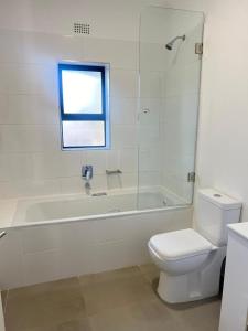 a bathroom with a tub and a toilet and a sink at Lhondeh Apartments in Livingstone