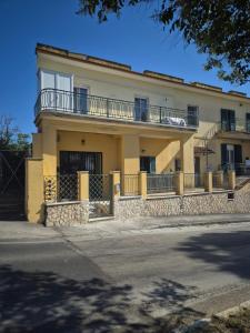 a yellow house with a balcony on a street at Mirabaia in Bacoli