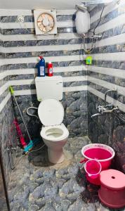 a bathroom with a toilet and a sink at priya inn royal in Lakhīmpur +3 photos