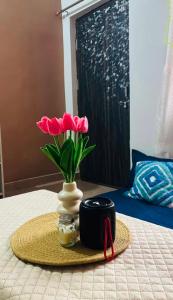 a table with a vase with pink flowers and a ribbon at priya inn royal in Lakhīmpur