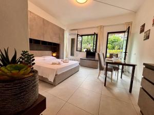 a bedroom with a bed and a table and a desk at Due laghi – Studio Apartment with Pool in Porlezza +41 photos