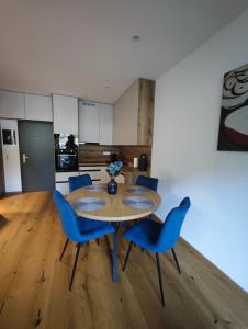 a dining room with a table and blue chairs at Apartmán Vyhne in Vyhne
