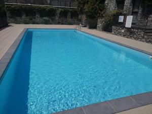 a large blue swimming pool in a building at Due laghi – Studio Apartment with Pool in Porlezza