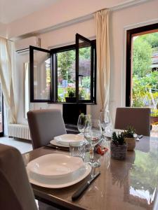a dining room table with plates and wine glasses at Due laghi – Studio Apartment with Pool in Porlezza
