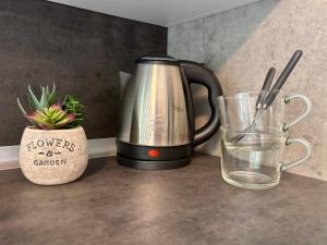 a tea kettle and a glass of water on a counter at Due laghi – Studio Apartment with Pool in Porlezza
