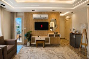 a living room with a desk and a tv on a wall at Premium Pyramids BoutiQue With Rooftop Access in Cairo