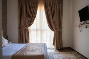a bedroom with a bed and a large window at N'Log N'Skuraj Hotel in Ferr -Skuraj