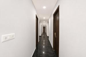 a hallway with white walls and a long wooden floor at FabHotel Snereya in New Delhi