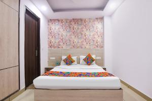 a bedroom with a large bed with a painting on the wall at FabHotel Snereya in New Delhi +23 photos