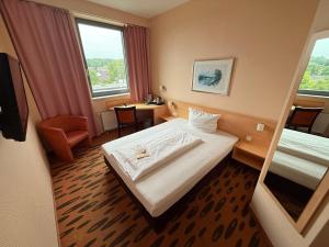 a hotel room with a bed and a window at Hotel Rhein-Ruhr by Mayburgh Bottrop Hauptbahnhof in Bottrop