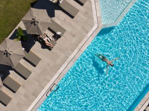 an overhead view of two people swimming in a swimming pool at Malena Hotel & Suites - Adults Only by Omilos Hotels in Amoudara Herakliou