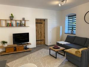 a living room with a couch and a tv at Stodl Living Chiemsee in Grabenstätt