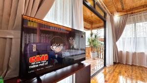a flat screen tv on a wall in a living room at Sapa Rose Garden Resort in Sapa