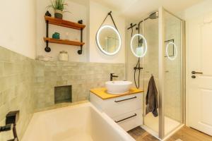 a bathroom with a tub and a sink and a shower at Townhouse Am Kurpark - Ferienhaus, 2 Schlafzimmer, Arcade, Wallbox, inklusive Wäsche in Braunlage