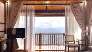 a living room with a large window with a view at Sapa Rose Garden Resort in Sapa