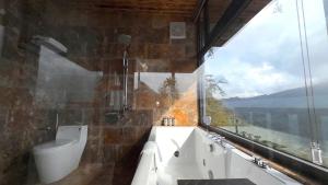 a bathroom with a tub and a toilet and a window at Sapa Rose Garden Resort in Sapa
