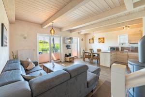 a living room with a couch and a kitchen at Ferienhaus Seestern in Dagebüll