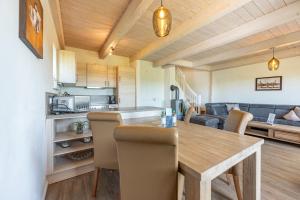 a kitchen and living room with a wooden table and chairs at Ferienhaus Seestern in Dagebüll +36 photos
