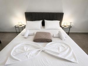 a large white bed with a bow on it at Coconut beach villas 1 in Schinias