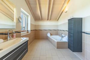 a bathroom with a tub and a sink at Ferienhaus Seestern in Dagebüll