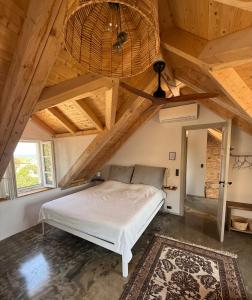a bedroom with a bed in a room with wooden ceilings at Mirca with seaview - charming stonehouse in Mirce