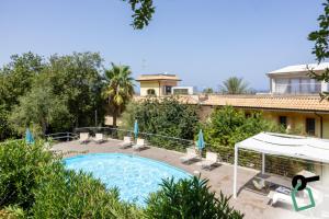 a swimming pool in front of a house at Hotiday Tropea Parghelia in Tropea