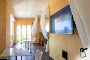 a living room with a flat screen tv on the wall at Hotiday Tropea Parghelia in Tropea
