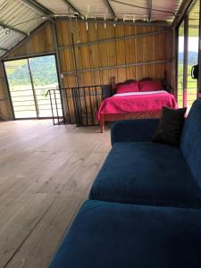 a living room with two beds and a couch at Cabaña Cherenga in Sarchí