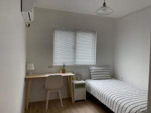 a bedroom with a bed and a desk and a chair at Chuncheon Diary Stay in Chuncheon