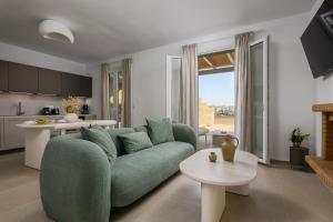 a living room with a green couch and a kitchen at Estia Villas Naxos in Naxos Chora