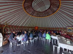a group of people sitting at tables in a yurt at Yurtcamp Rahat&Horse Trekking in Kyzylemgek