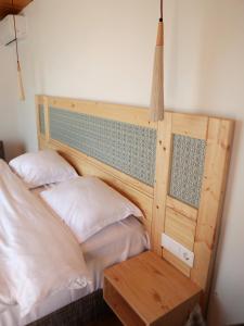 a bed with a wooden headboard with two pillows at Cabana din vale in Cioclovina