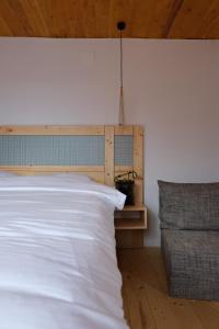 a bedroom with a white bed and a chair at Cabana din vale in Cioclovina