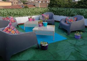 a patio with chairs and tables and potted plants at La Casa De Marta in Piedralaves
