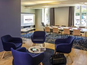 a meeting room with chairs and a projection screen at Mercure Beauvais Centre Cathédrale in Beauvais